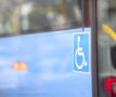 Zijkant van een bus, met logo voor mensen met een beperking.