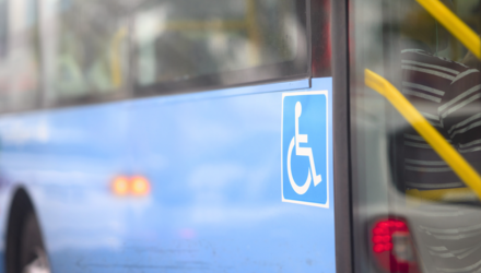Zijkant van een bus, met logo voor mensen met een beperking.